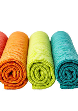 Five colorful rolled microfiber cleaning cloths in a gradient on a white background with copy space, concept of household cleaning and organization