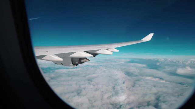 Airplane window view of flight flying through clouds for travel concept in 4K Ultra HD footage
