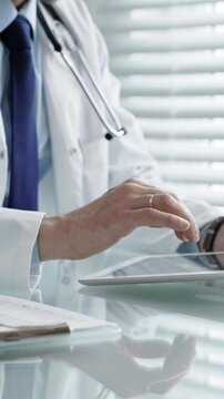 Healthcare professional wearing a lab coat and stethoscope, using a tablet and laptop, collaborating with technology for medical research, digital records, and remote patient care