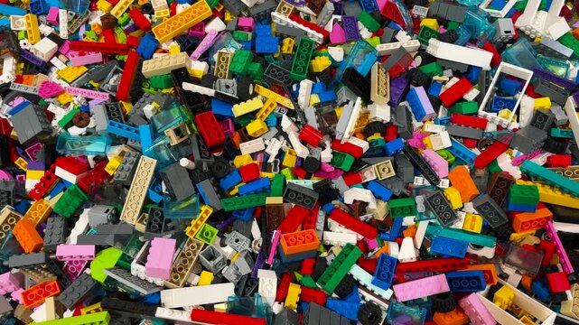 A pile of colorful plastic building blocks stored in a box. toys that foster a child's creativity.