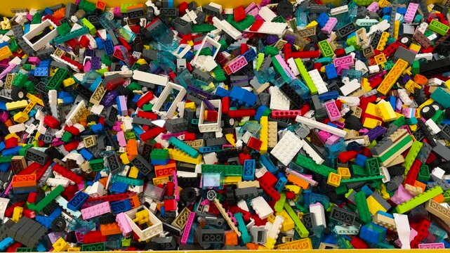A pile of colorful plastic building blocks stored in a box. toys that foster a child's creativity. toys that children like