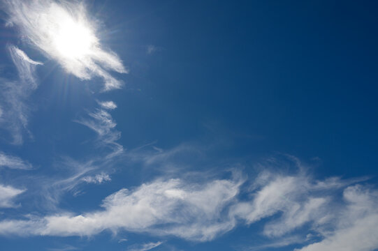 Bright Blue Sky with Scattered Cirrus Clouds and Strong Sunlight
