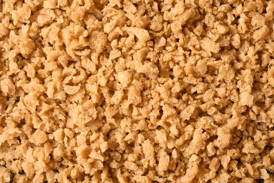 soaked brown soy meat flakes in full frame, hydrated textured vegetable protein background, flat layer food top view, healthy vegan diet ingredient