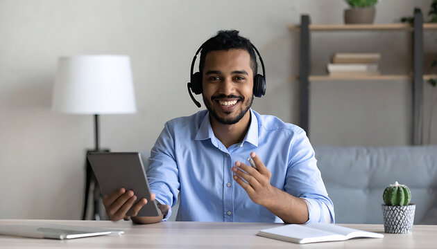 Smiling man in headset using digital tablet for video call, remote support, online communication, customer service, business consultation