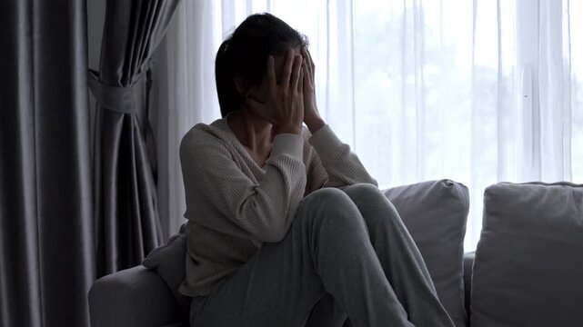 Depressed woman in darkness suffering from depression and trauma. 4K concept of social support and women protection awareness.