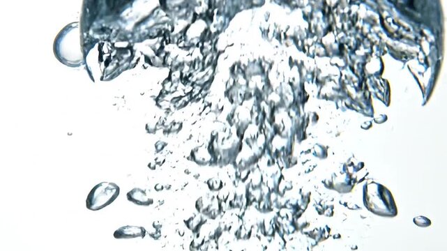 Water droplets splash and fall in a mesmerizing display of liquid movement and clear transparent fluid dynamics in a clean environment.