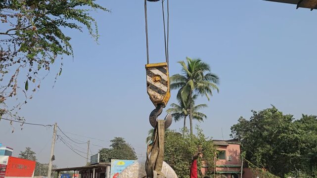 Mobile crane boom with heavy-duty lifting hook suspended against clear blue sky. Industrial lifting equipment, engineering machinery, infrastructure development, heavy construction
