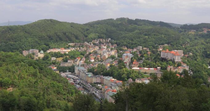 4K panning right motion of breathtaking view of the city buildings and surrounding mountains of the Karlovy Vary area, view from the observation deck of the Diana lookout tower, Karlovy Vary, Europe