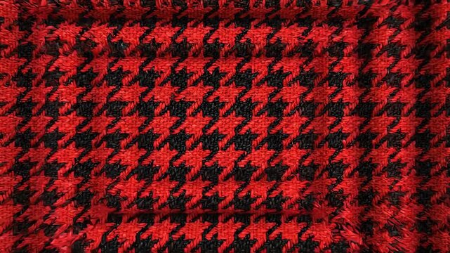 Abstract red and black houndstooth grid scaling inward slowly creating a hypnotic seamless loop of classic textile pattern