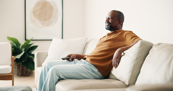 Happy, relax and black man watching tv on sofa for entertainment or online subscription in home. Male person, chilling and smile with remote on couch for movie, series or streaming app in house