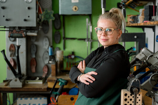 Female shoemaker standing in her craft workshop