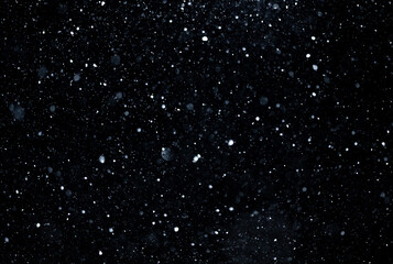 Fototapeta premium Snow overlay layer on dark background. Snow particles drifting in winter storm. Snow texture with falling snowflakes. Snowfall effect with cold motion.