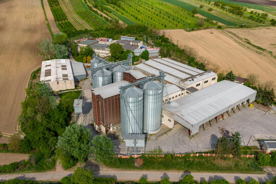 Aerial view of the grain silo facility in Strazovice, surrounded by agricultural fields and green trees in the South Moravian Region, Czechia.