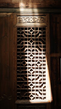 The old wooden door with the sculptures on it in the old traditional Chinese house