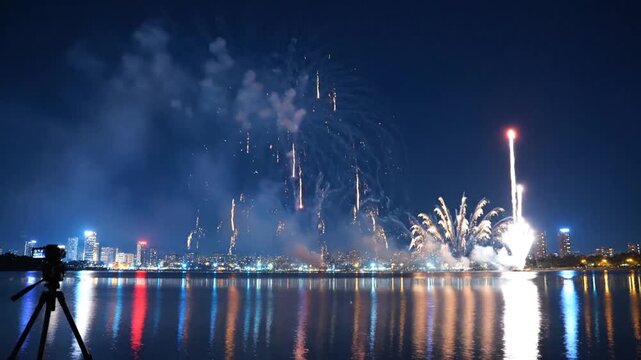 Fireworks exploding over urban skyline and water