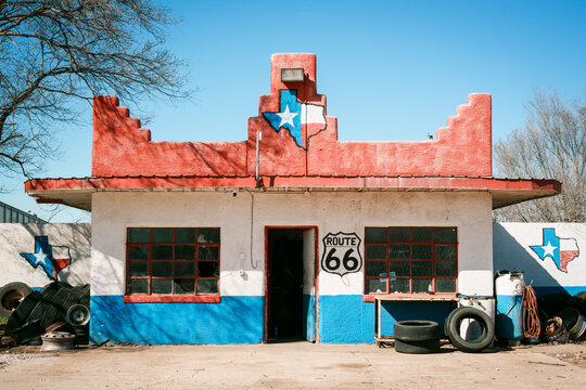 A vintage gas station on Route 66, adorned with Texas symbols and surrounded by old tires near Shamrock, Texas