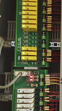 Relays activate systematically. Industrial relay startup procedure. Sequential powerup for relay systems. Methodical process of energizing relay units in industrial environment with visual signals