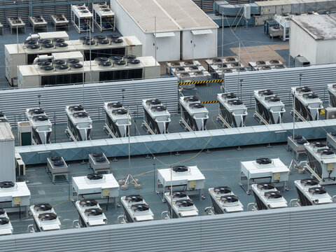 Aerial view of an AI data center rooftop featuring rows of industrial cooling fans and HVAC units in a modern facility in Warsaw, Masovian Voivodeship, Poland.