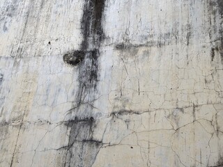 Distressed concrete wall texture with cracks and vertical water stains. Grungy, weathered surface. © suciramadhani