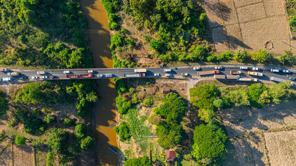 Fototapeta premium Surrounded by agricultural fields and lush green forest, the accident scene highlights the importance of this key river crossing route connecting local communities.