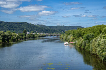 Fototapeta premium der Weg nach Trier. Von hier oben wirkte der Fluss wie ein ruhiges Band, das sich geduldig durch die grüne Landschaft zieht. In der Ferne spannt sich die Römerbrücke über das Wasser, dahinter verschwi