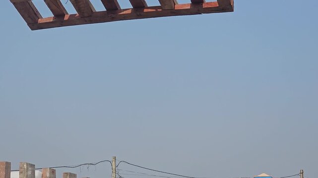 Mobile crane lifting wooden box. Heavy-duty lifting equipment, engineering, and industrial machinery under a clear blue sky. Ideal for construction companies, engineering firms, infrastructure project