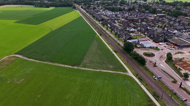 Aerial shot following dutch railway separating town and countryside