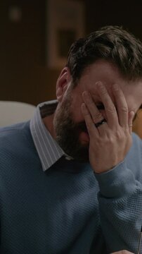 Facepalm. Frustrated bearded man puts his hand to his face. Close-up vertical