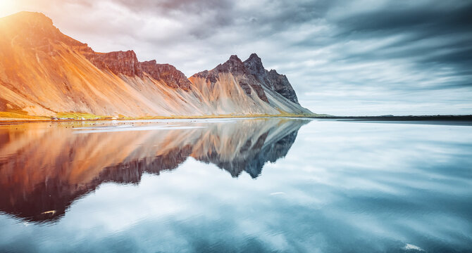 Gorgeous mountain peaks reflected in serene waters at Stokksnes cape. Location place Vestrahorn (Batman Mount), Iceland, Europe.