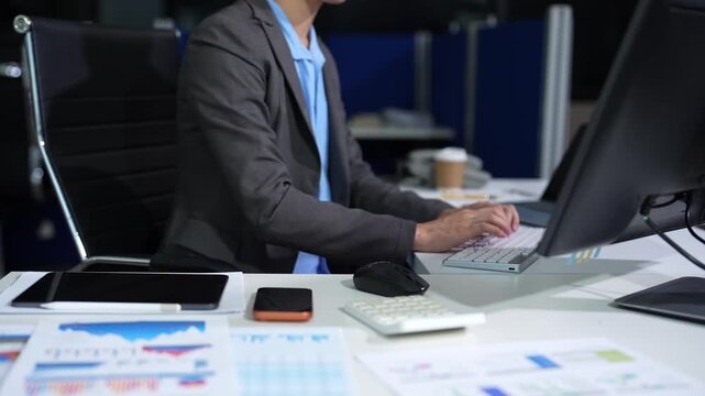 Business man working at office with laptop and documents on his desk, financial adviser analyzing data.