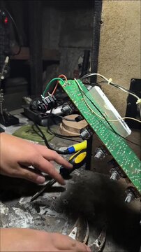 Close up of an open audio amplifier circuit board during maintenance, vertical shot