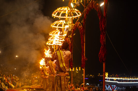 Ganga aarti, Portrait of young priest performing holy river ganges evening aarti at assi ghat in traditional dress with hindu rituals.