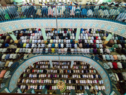 Dhaka, Bangladesh - 26 June 2026: Aerial view of Baitul Mukarram National Mosque filled with people praying in rows on multiple levels, showcasing architectural details and a chandelier.
