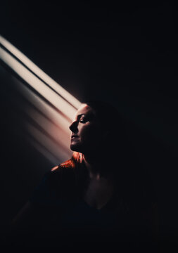 Woman in profile with eyes closed in sunbeam