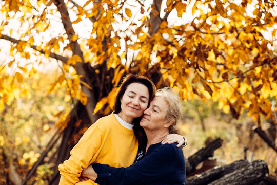 Senior mother and adult daughter share a warm hug