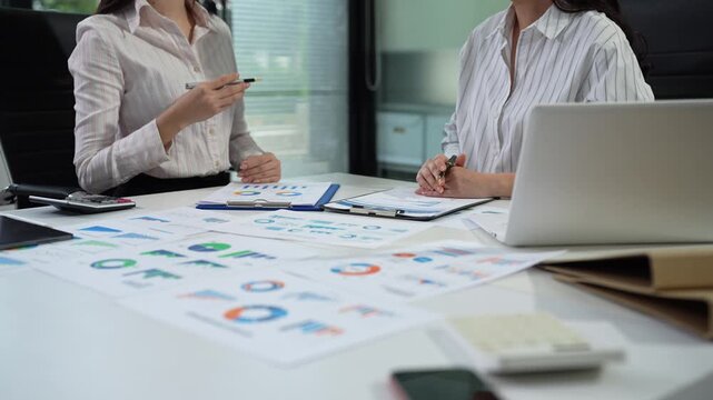 Professionals collaborate on project analysis with financial graphs. Strategic teamwork and insights drive company growth and success.