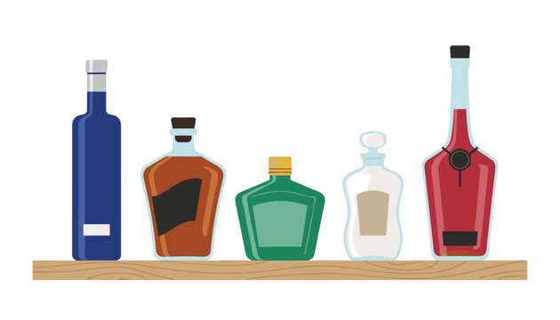 Selection of five various glass alcohol bottles of whiskey, gin, and cognac standing on a wooden shelf, isolated on white.