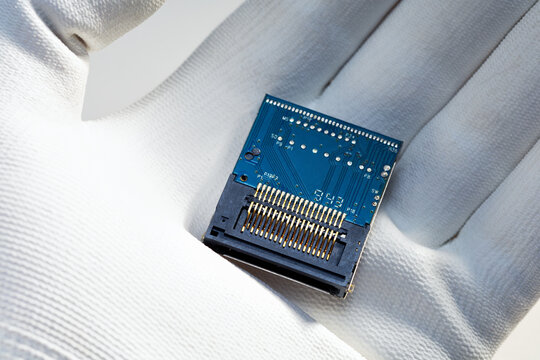 AI microchip on human hand in a white glove.   Computer microchip for electronics production.