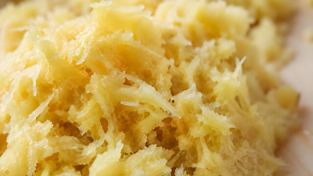 Macro view of freshly grated ginger root pulp showing fibrous texture
