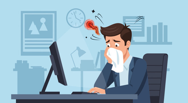 Sick Businessman Sneezing at His Desk, Feeling Ill and Unwell in the Office