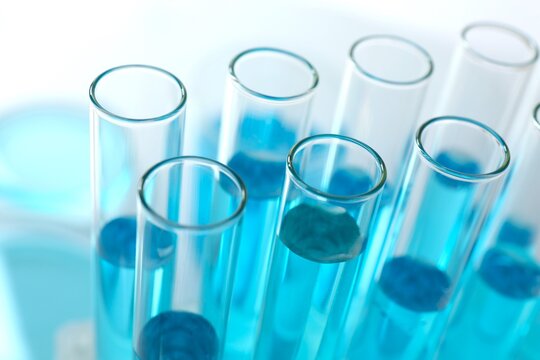 Test tubes with light blue liquid in laboratory, closeup