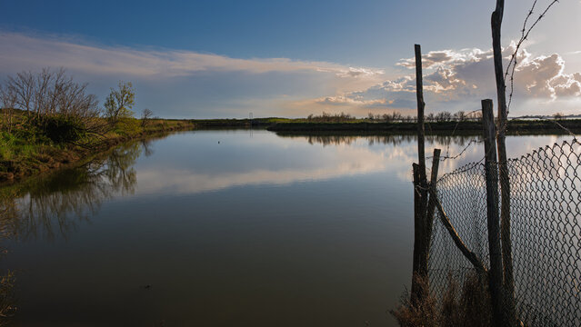 sunset over the lagoon inside the river Po delta with a dramatic sky in the background, Porto Levante, Rovigo, Italy