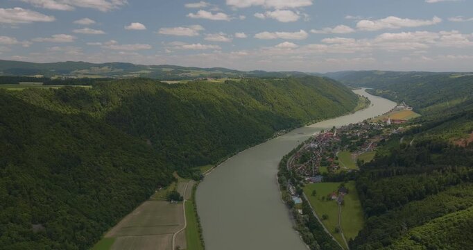 Beeindruckende Luftaufnahme der Donau sanften H&uuml;geln in Bayern. Panorama einer malerischen Flusslandschaft an einem sonnigen Sommertag.