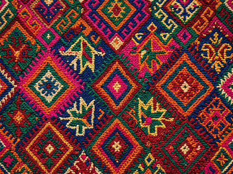 Vibrant embroidered fabric with intricate geometric patterns and floral motifs
