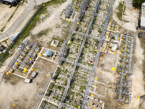 Aerial view of the CFE SE Norte electrical substation with metal power structures and electrical equipment on a gravel site in Merida, Yucatan, Mexico.