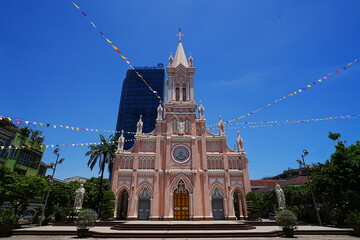 The beautiful Pastel Pink Da Nang Cathedral under a clear blue sky in Vietnam - ベトナム 観光名所 ピンク色 ダナン大聖堂 © Eric Akashi