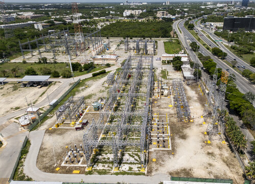 Aerial view of the CFE SE Norte electrical substation with metal power structures, transformers, and electrical equipment located near a highway in Merida, Yucatan, Mexico.