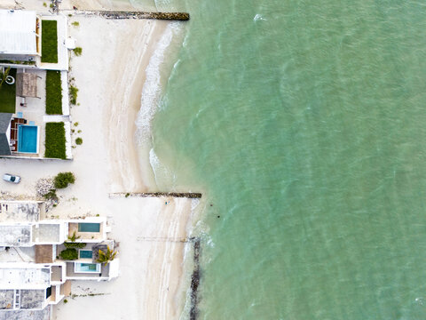 Aerial view of the coastline at Chuburna, featuring white sand beaches, turquoise Caribbean waters, and modern beachfront villas with private pools in Chuburna, Yucatan, Mexico.