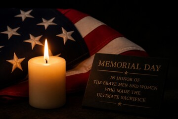 Fototapeta premium Candle glows softly beside an American flag. Black plaque honors brave men and women. Symbolic tribute to those who sacrificed everything. Suitable for solemn remembrance or patriotic events