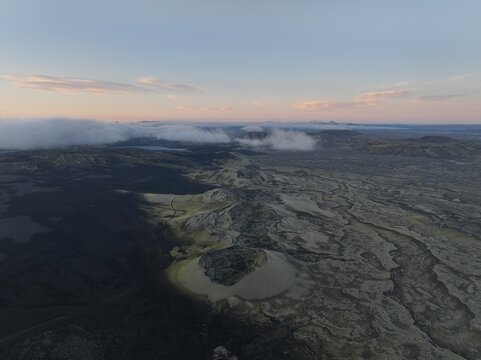Aerial view of Laki volcanic craters surrounded by vast moss-covered lava fields under a soft sunset sky, Kirkjubaejarklaustur, Skaftarhreppur, Iceland.